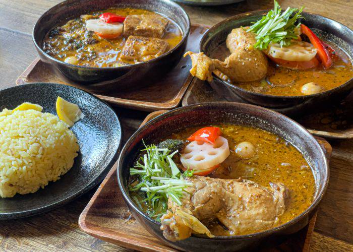 Three bowls of Hokkaido soup curry, with tender meat and veggies soaking in a flavorful broth.